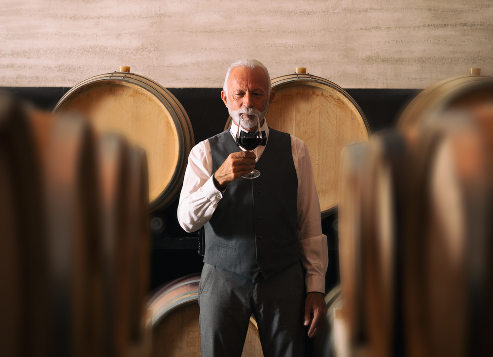 Senior,Winemaker,In,Elegant,Suit,Standing,By,Wooden,Barrels,In